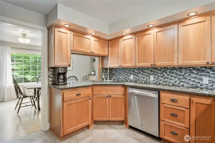 Kitchen with custom wood cabinets, granite countertops, gas range, and stainless appliances Kitchen with custom wood cabinets, granite countertops, gas range, and stainless appliances