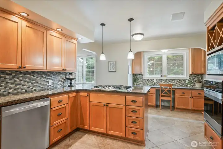 Kitchen with custom wood cabinets, granite countertops, gas range, and stainless appliances Kitchen with custom wood cabinets, granite countertops, gas range, and stainless appliances