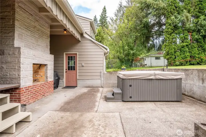 Patio area with hot tub, and outdoor gas fireplace Patio area with hot tub, and outdoor gas fireplace