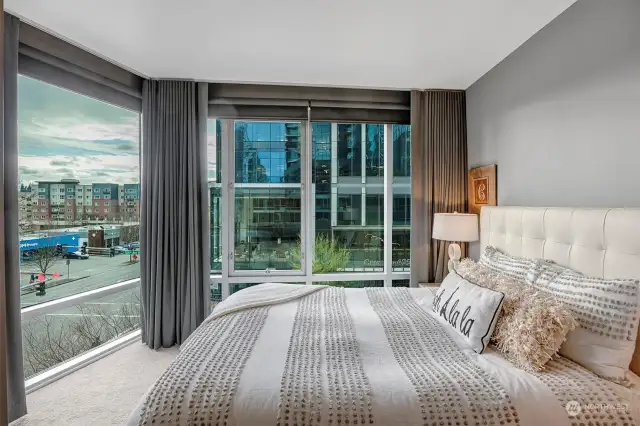 The primary suite features a wall of windows with custom drapes and role shades.