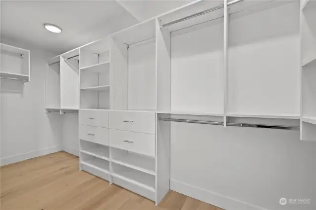 Spacious primary bedroom closet with shelving system.