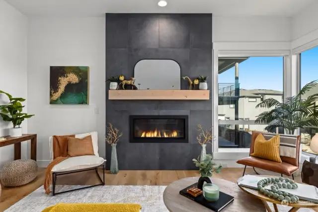 Gas fireplace with wood mantel and floor to ceiling tiling.