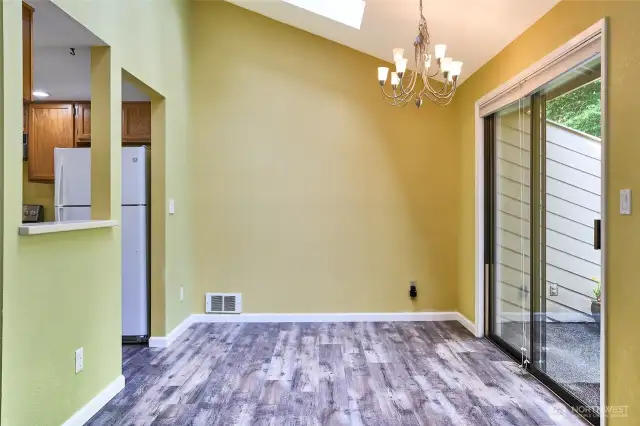 The living room flows into the dining area with skylight and slider to backyard patio.