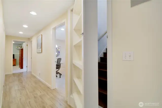 Staircase to lower level, w/bookshelf door