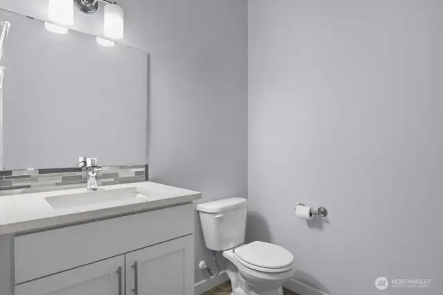 Powder bath tucked away behind kitchen.