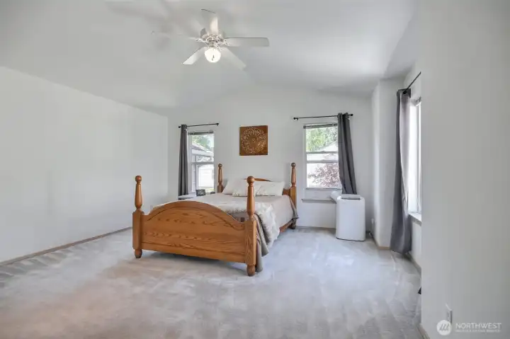 The spacious primary bedroom has vaulted ceilings.