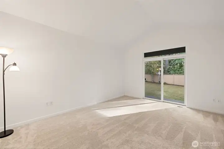 Primary bedroom with slider to rear yard and patio