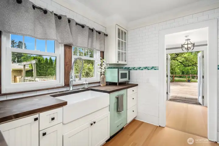 Kitchen looking through sun room with French doors to deck.