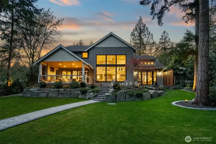 Expansive windows look out at the one acre parcel and protected land beyond.