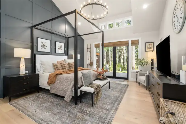 Vaulted ceilings and a board and batten wall running the length of the primary bedroom.