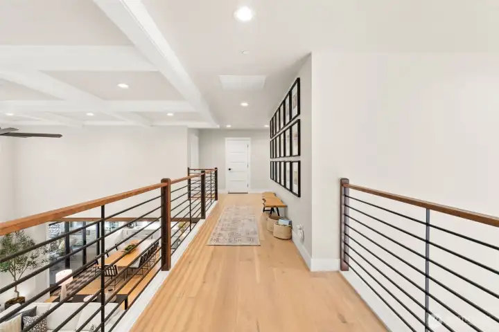The second floor catwalk allows you to look towards the front door on one side, and the living room and kitchen on the other.