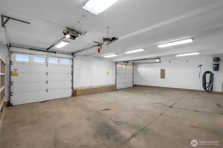 Large garage space with storage room and 3/4 bath