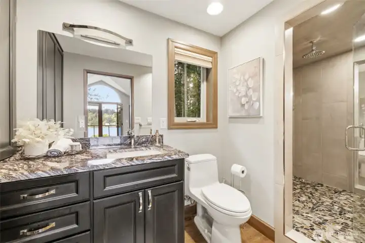 Primary bathroom has dual vanities & toilets with a shower-steam room in-between.