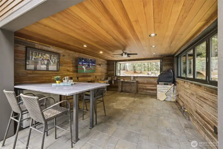 Covered outdoor kitchen includes a gas pizza oven!