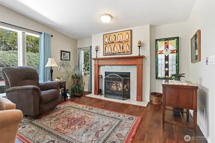 Family room opens to the kitchen and also has a sliding door to the sunroom.  Features vaulted ceilings, LVP flooring and a wood fireplace.