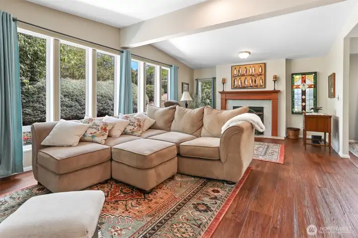 Family room opens to the kitchen and also has a sliding door to the sunroom.  Features vaulted ceilings, LVP flooring and a wood fireplace.