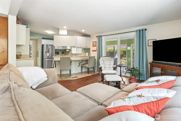Family room opens to the kitchen and also has a sliding door to the sunroom.  Features vaulted ceilings, LVP flooring and a wood fireplace.