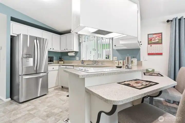 Updated kitchen features quartz counters, wall oven, cooktop, a pantry and an eating bar that opens to the family room.