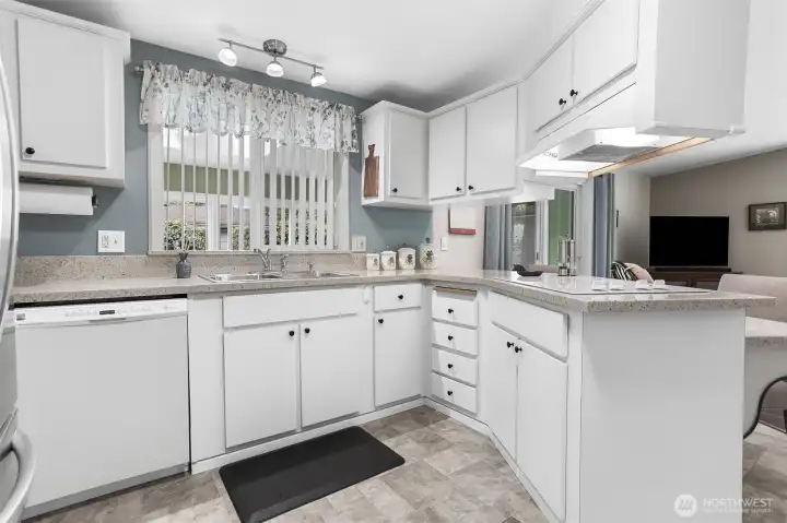 Updated kitchen features quartz counters, wall oven, cooktop, a pantry and an eating bar that opens to the family room.