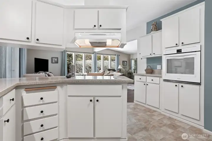 Updated kitchen features quartz counters, wall oven, cooktop, a pantry and an eating bar that opens to the family room.