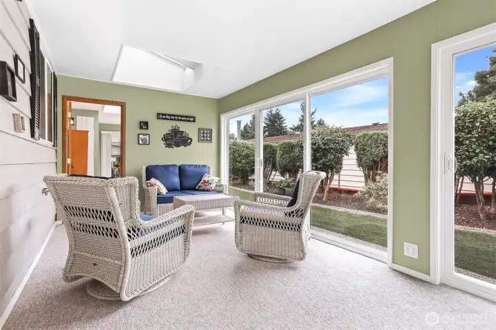 Light and bright sun room accessed from the family room features many new vinyl sliding doors, sun screen shades and skylights.  (Extra 400 sq ft not included in the home size per SCR)