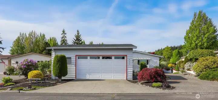 240th side with access to the detached 2 car garage and custom low maintenance landscaping with a dry river.