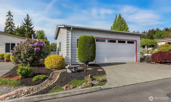 240th side with access to the detached 2 car garage and custom low maintenance landscaping with a dry river.