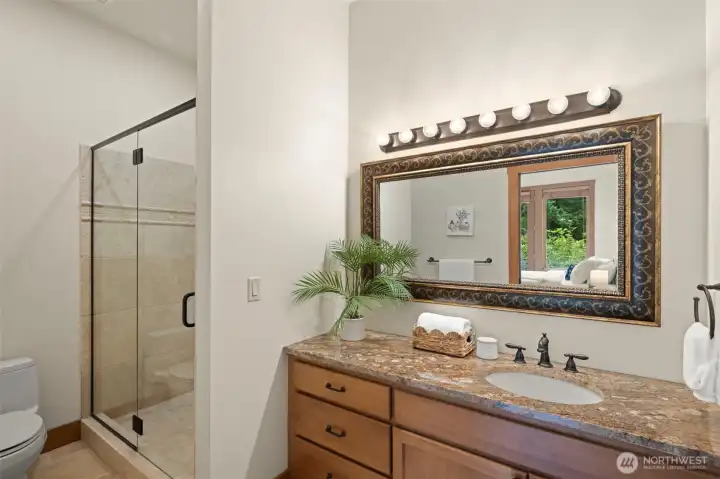 Primary bath with tile shower and granite countertops