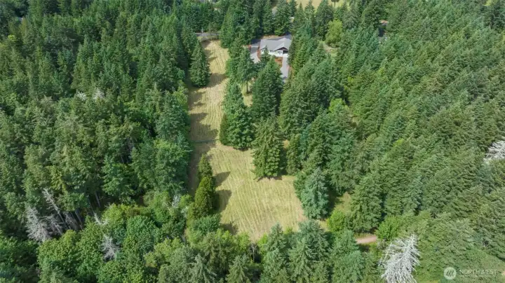 Aerial view from rear of property highlighting 2 mowed pastures and rear of house