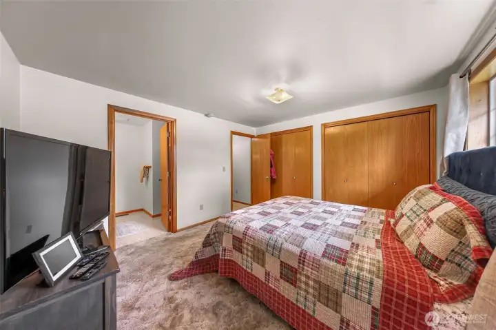 view of the primary bedroom with a private 3/4 bath and 2 closets!
