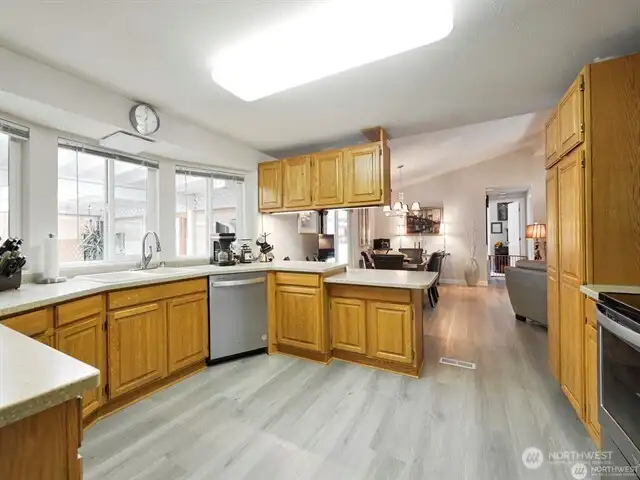 Wow! The light and bright kitchen is spacious and well laid-out, with newer cabinetry and Corian counter-tops. You’ll love the gorgeous and durable luxury flooring throughout the living spaces. Newer vinyl windows and soaring vaulted ceilings enhance the spacious and elegant feel of your new home. And the stainless steel kitchen appliances also remain with the home.