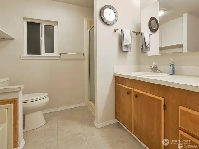 The primary bath is spacious and offers both a step-in shower and a soaking tub. Everything is fresh, gleaming, and ready for you!
