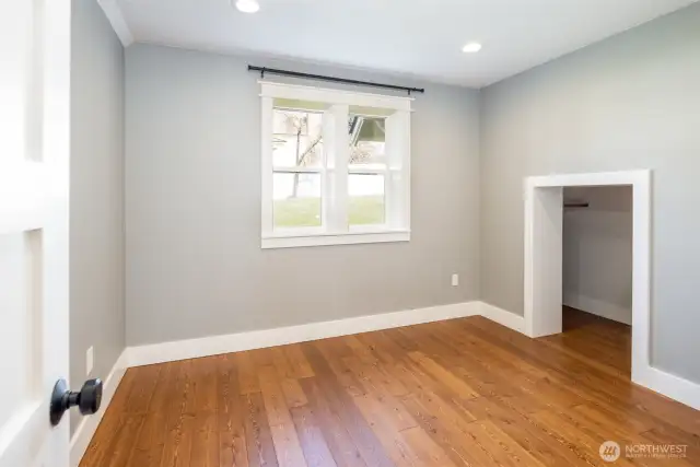 Large bedroom on the main floor with wood floors.