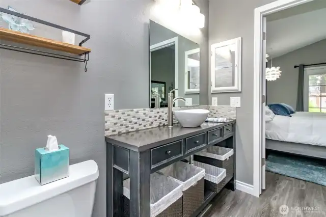 The vanity includes a unique sink bowl, updated faucet/light fixtures and lots of baskets for storage.