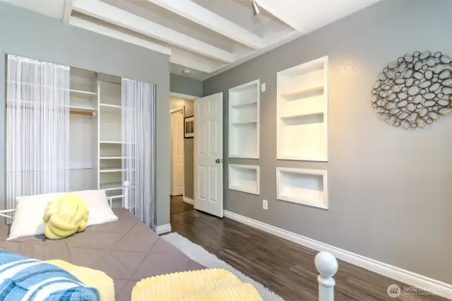Another view of the second bedroom showcasing the built-ins and closet. There is also a mini loft above half of the room.