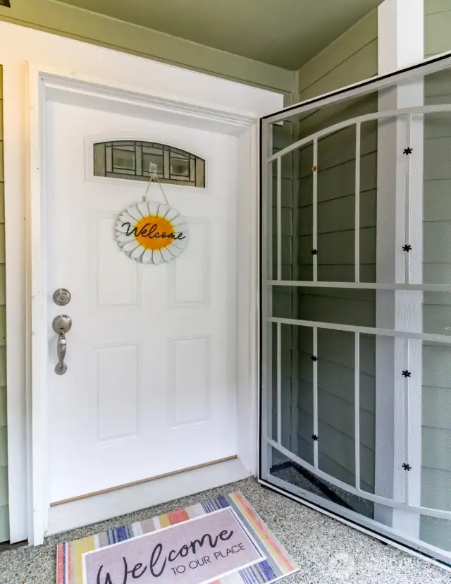 An inviting front door with a locking screen door.