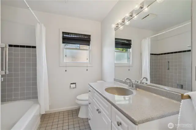 Main floor full bath with tiled surround.