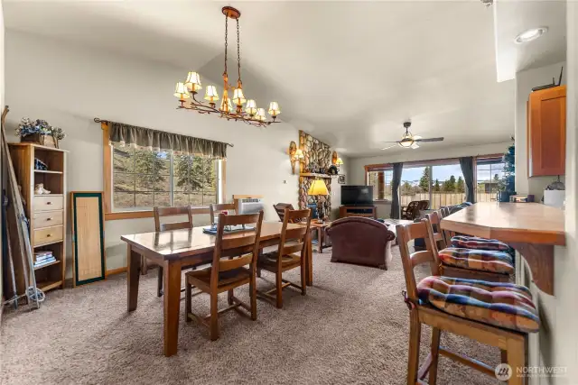 Open, great room concept - kitchen on the right, with eating space at the bar, dedicated dining area that flows into living space.