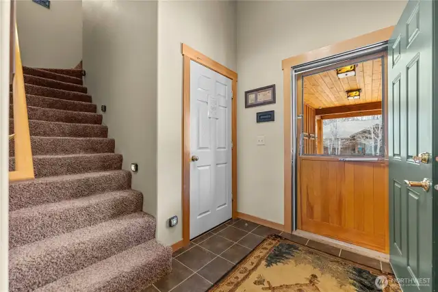 Front entry, with screen door and convenient access to the attached one-car garage.