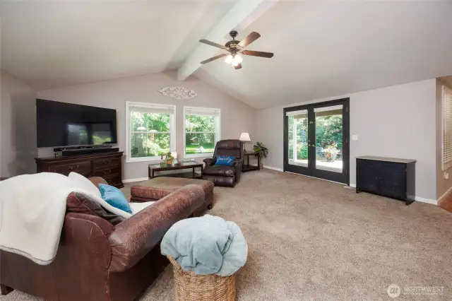 Oversized family or recreation room offers vaulted ceilings and French doors to the deck and private yard.