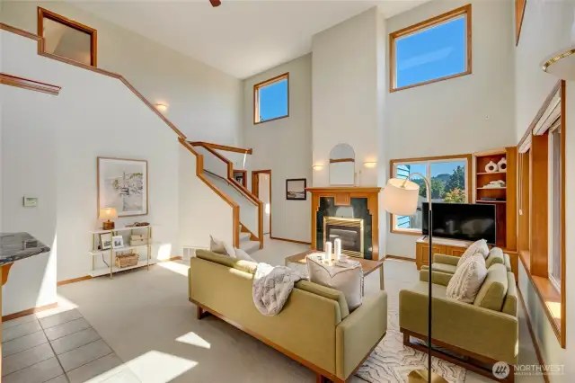 Bright Living Space Featuring Fireplace and Open Staircase