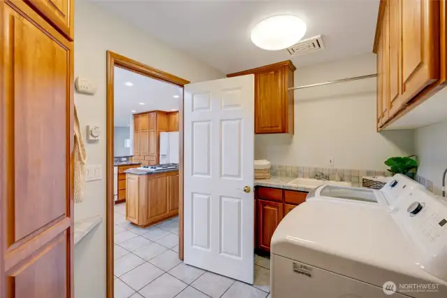 Laundry room conveniently located off the kitchen, with direct access to both the garage and basement.