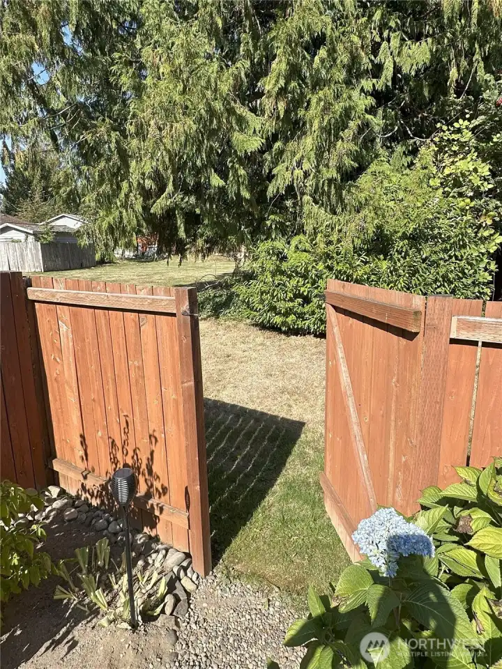 The fenced Backyard the Gate opens to the Common Area