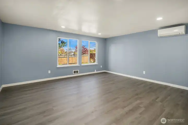 Bright and airy living area with large picture windows that bring in abundant natural light and showcase the front yard view.