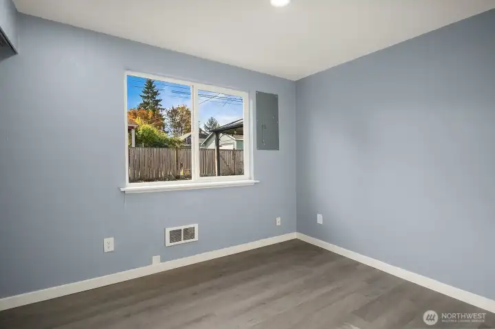 Comfortable bedroom with serene backyard views and neutral finishes.