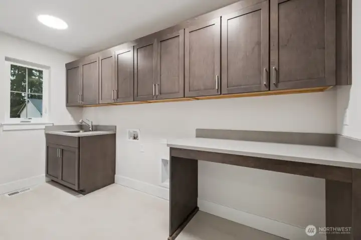 Second floor laundry with plenty of storage, counter space, and a sink. There's even room to tuck away your laundry hampers.