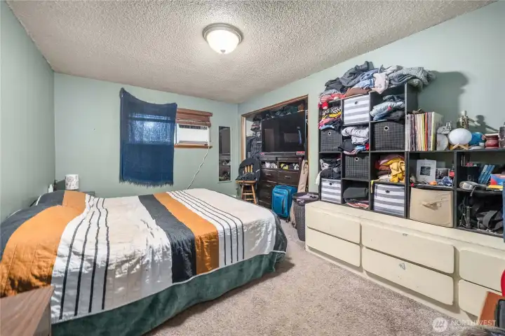 Unit 1 Generous primary bedroom with wall-to-wall carpeting, overhead lighting, and a wide closet opening that provides substantial storage and organization options.