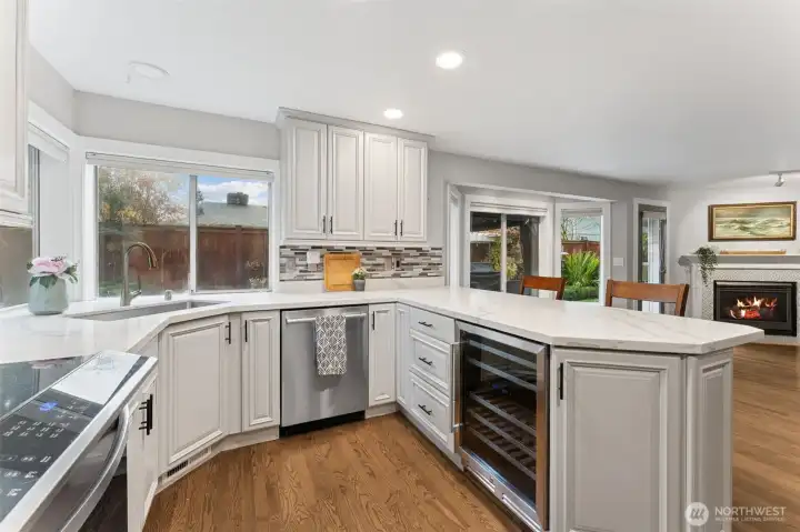 Kitchen view two towards your family room, large windows bringing in all the views and the light. Note the wine fridge!
