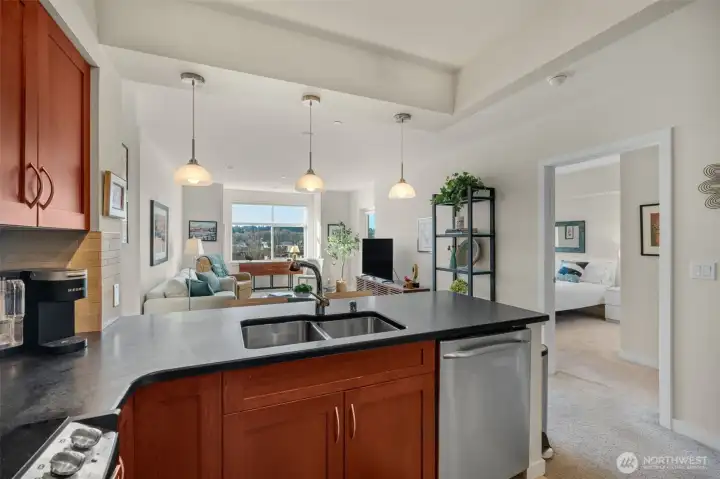 The timeless kitchen features shaker-style cabinetry, honed granite counters with bar-top seating, and stainless steel GE appliances.