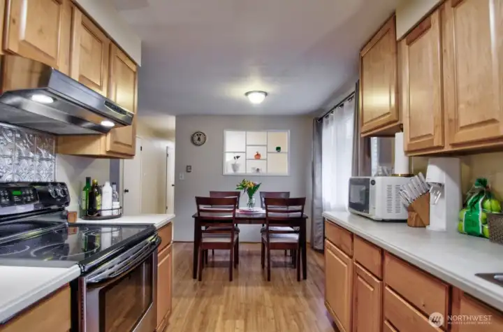 Spacious kitchen with plenty of cabinet space and unique built in shelving in the dining area wall